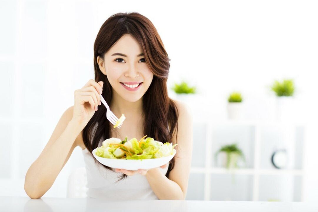 La femme japonaise mange une salade